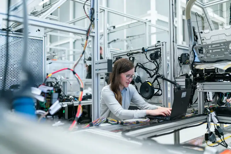 Engineer in PPE reviewing work on a laptop